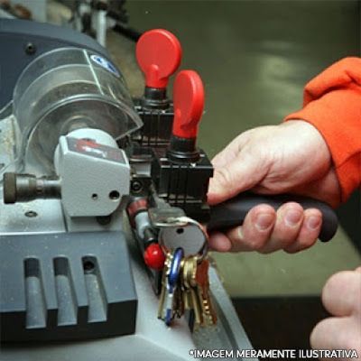 A person is cutting a bunch of keys on a machine