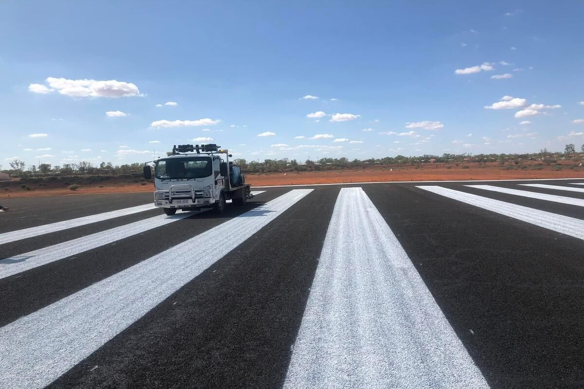 A Truck Is Driving Down A Road With White Stripes On It — Spraywayz Linemarking Pty Ltd In Booral, QLD
