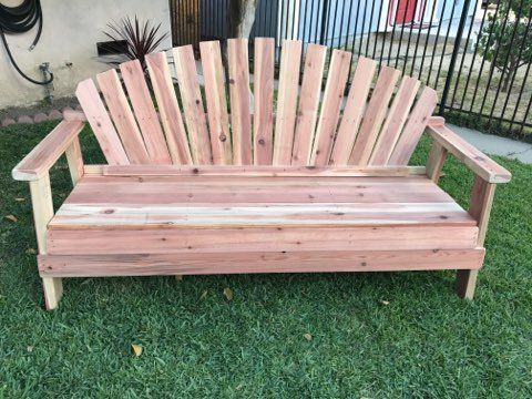 A wooden bench is sitting on top of a lush green lawn.