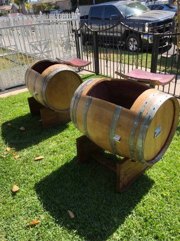 Two wooden barrels are sitting on top of a lush green field.