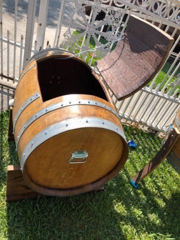 A wooden barrel is sitting on top of a lush green field.