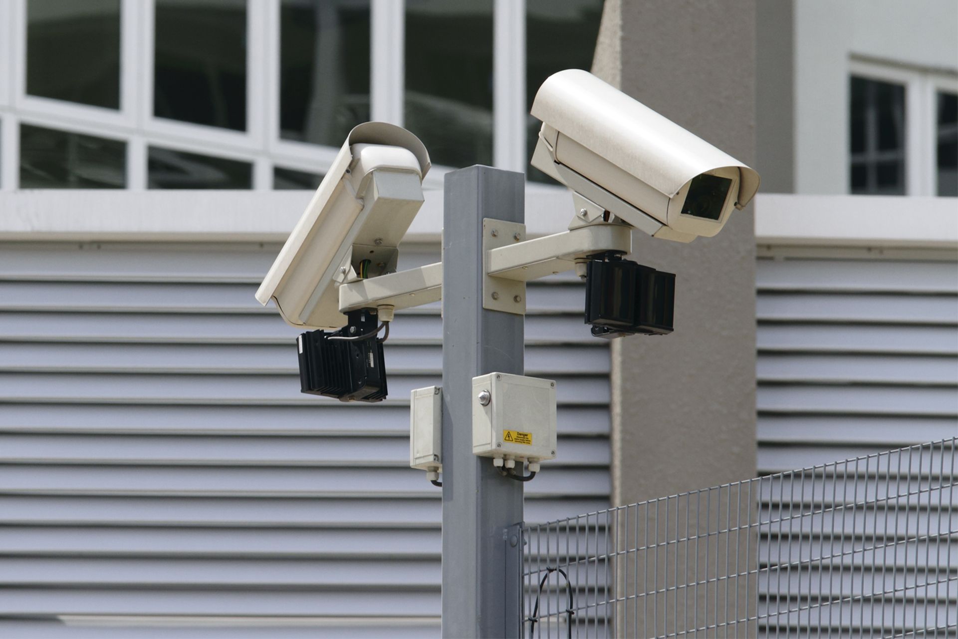 Two security cameras mounted on a metal pole