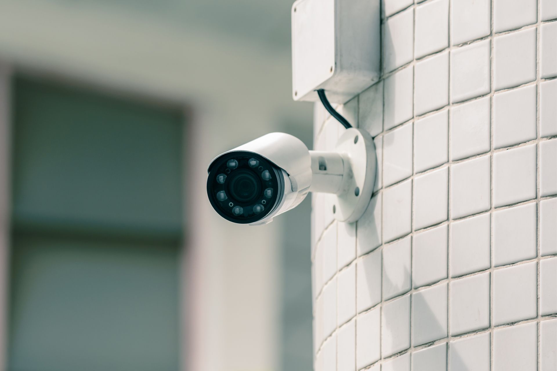 White security camera mounted on a white tiled column
