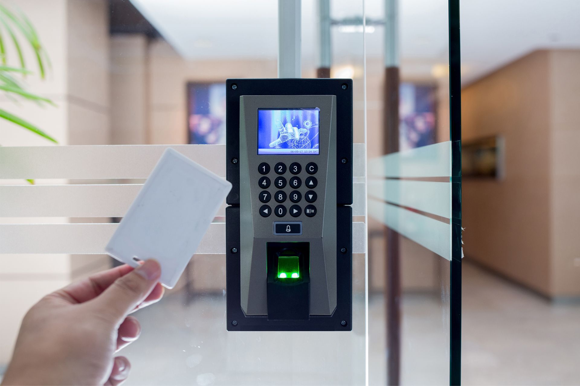 Hand holding access card near a security door system