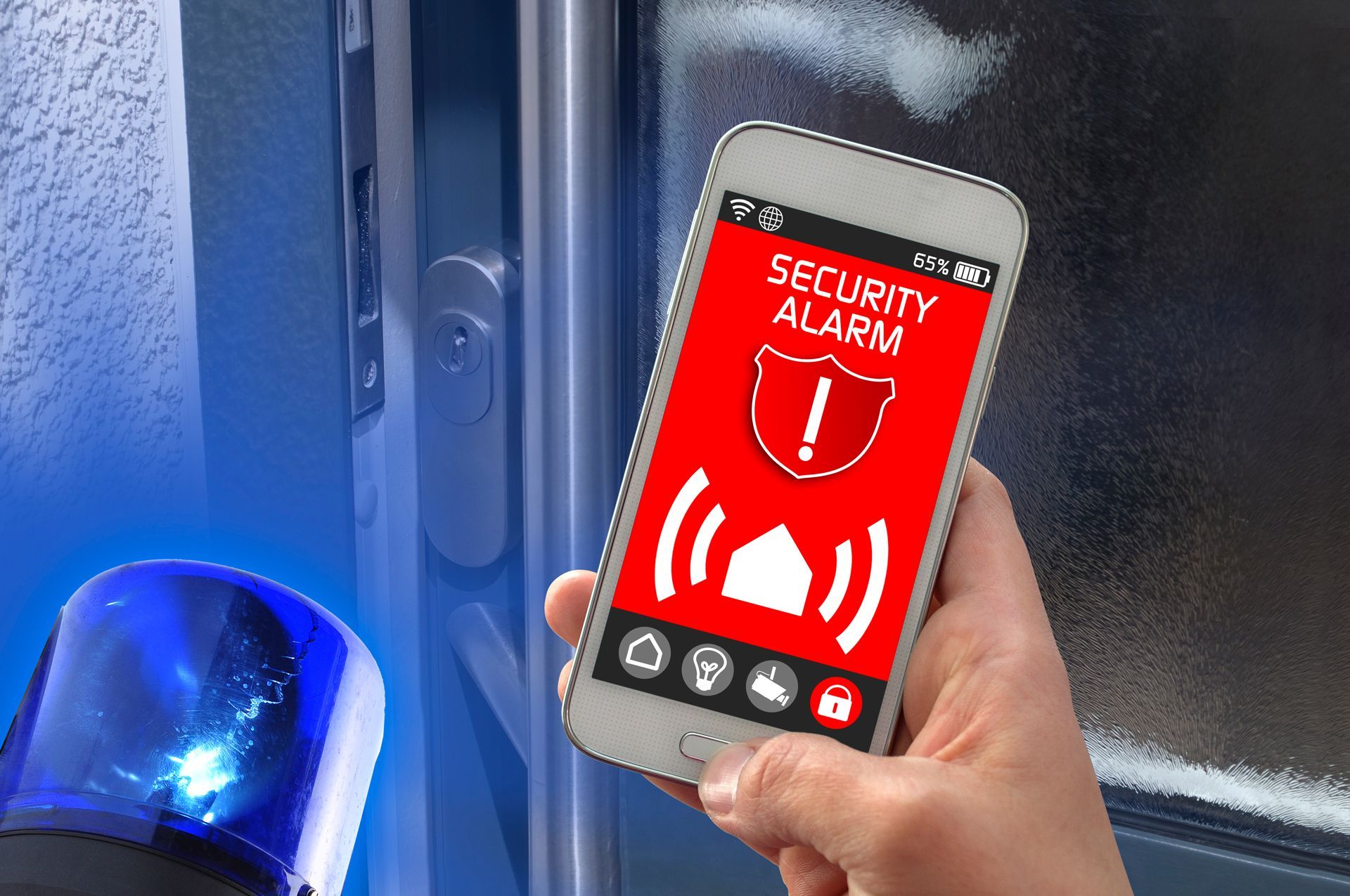 A hand holding a smartphone displaying a red security alarm
