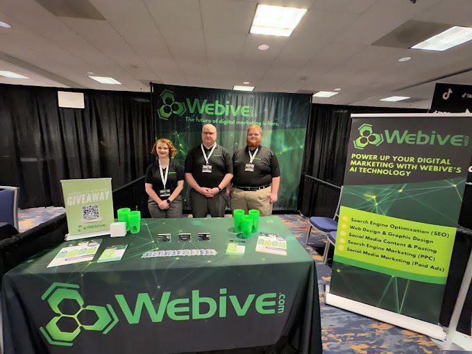 A group of people standing around a table with a sign that says ' webive ' on it.