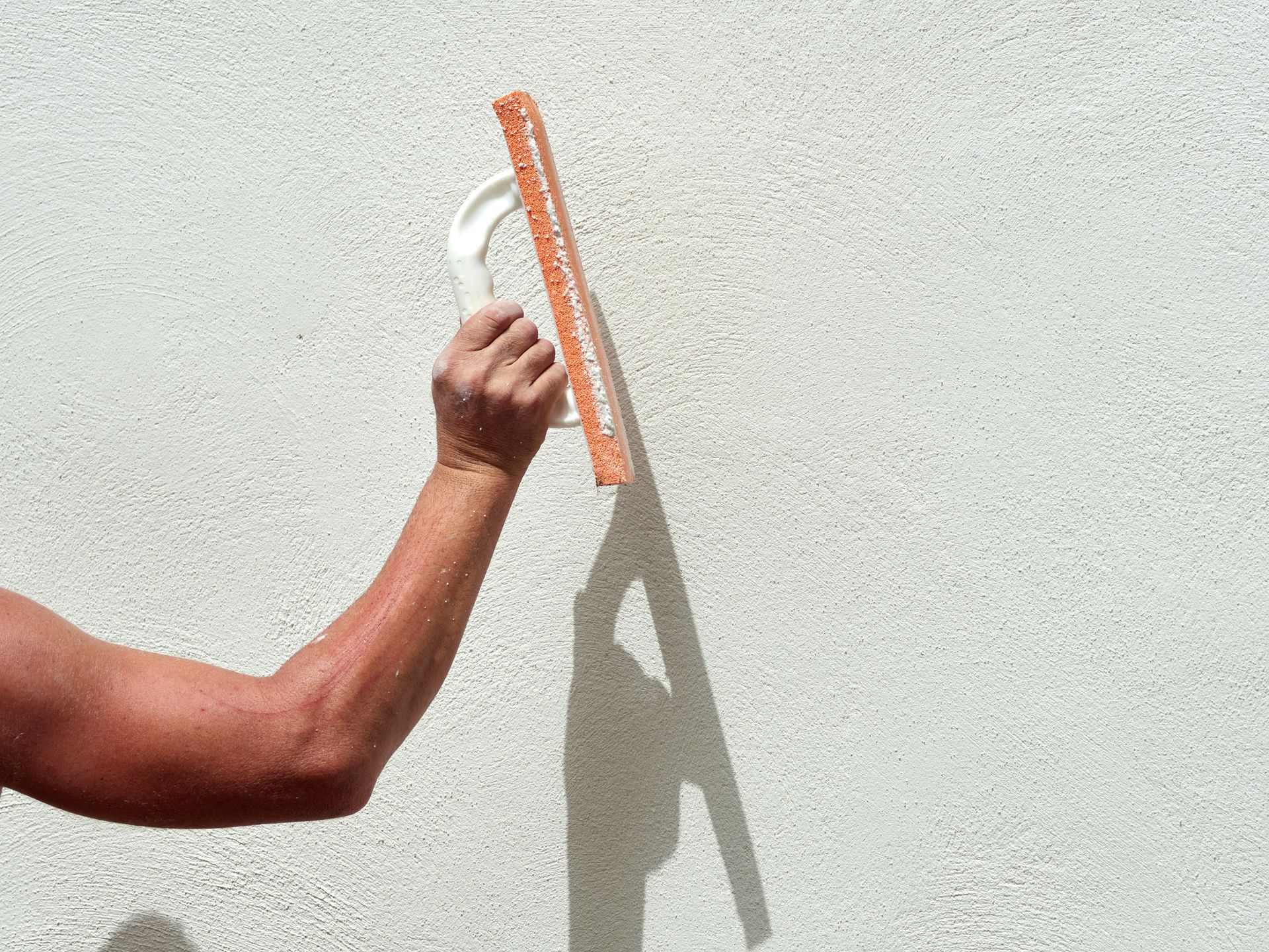 A person is using a trowel to plaster a wall.