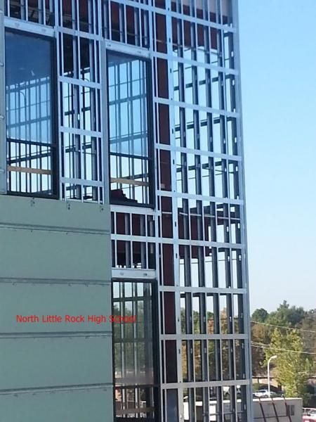 Metal framing under construction on the exterior of North Little Rock High School, showing windows and building facade.