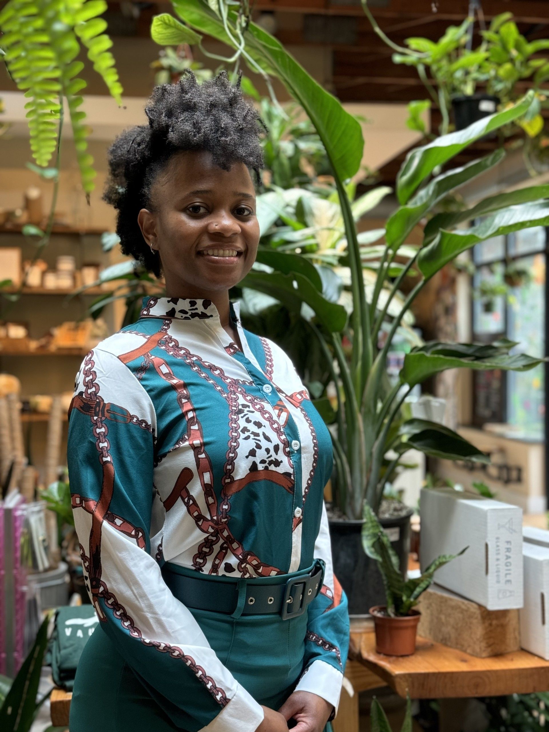A woman is standing in front of a bunch of potted plants.  - WrightNow Counseling – Philadelphia, PA