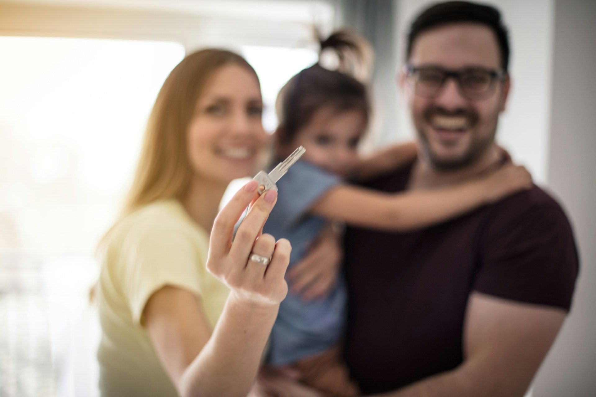 Family of three happily holding a pregnancy test.