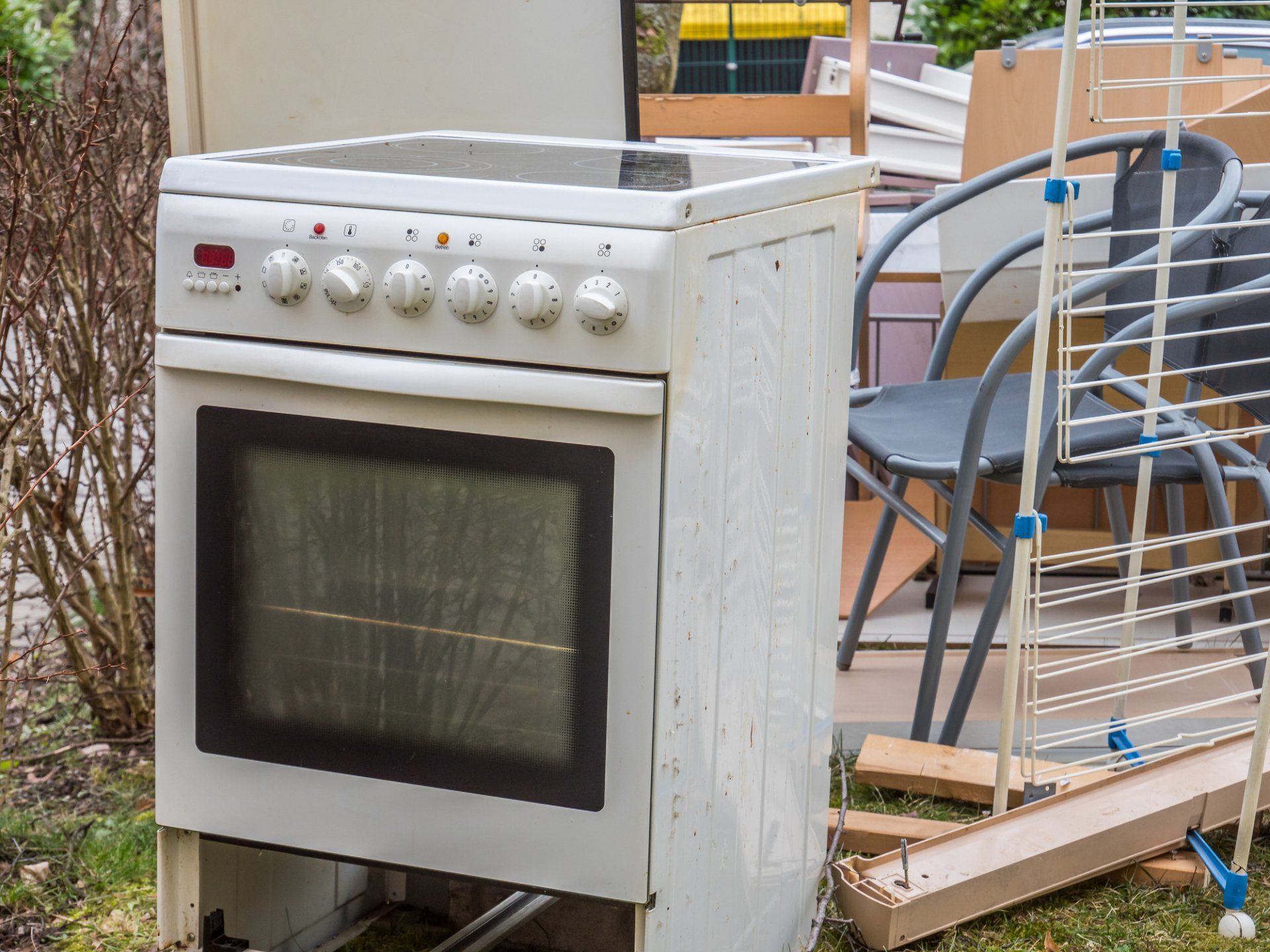 A white stove is sitting on top of a pile of junk.