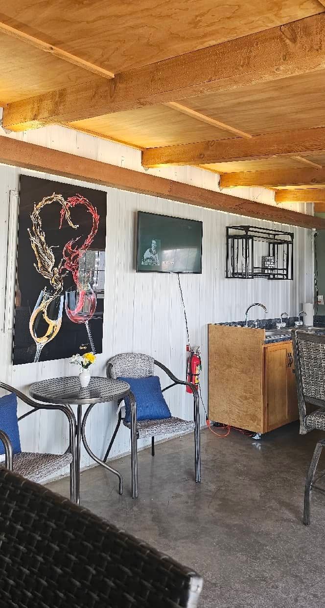 A wine tasting room with a table and chairs and a painting on the wall.