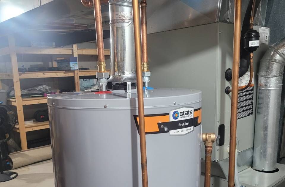 A water heater is sitting in a basement next to a furnace.