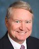 A man in a suit and tie is smiling for the camera.