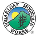 The logo for sugar loaf mountain works shows a mountain and a tree in a circle.