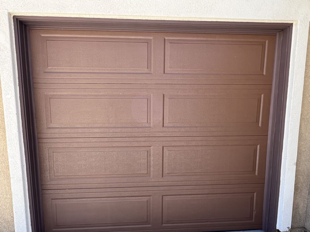 Brown closed garage door with six rectangular panels.