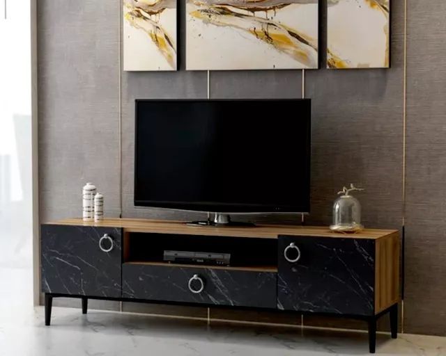 TV console with black marble doors, wooden top, silver ring handles, TV, and abstract art.