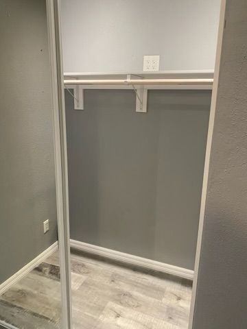 Empty gray closet with a shelf and hanging rod.