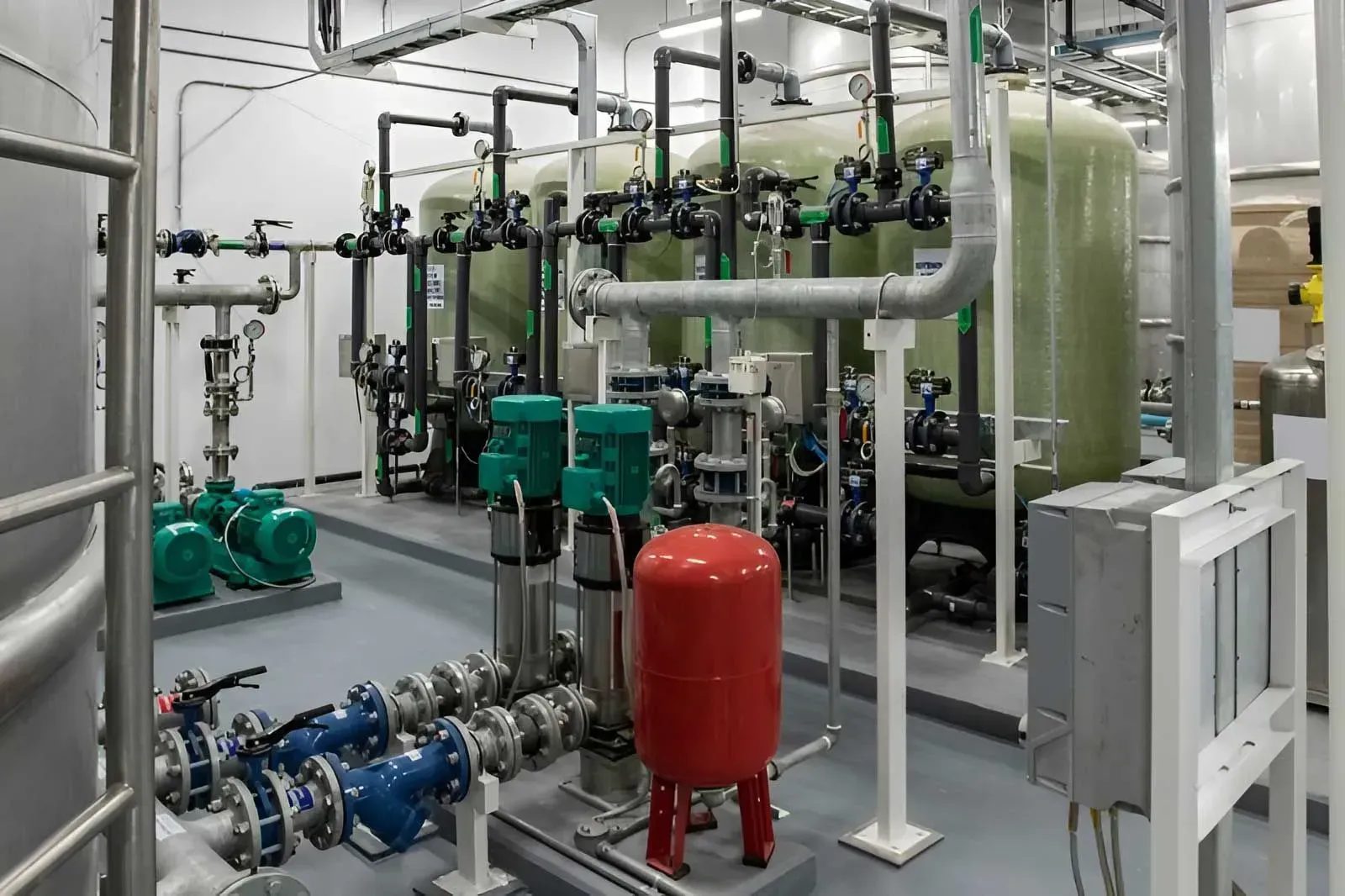 Industrial Water Treatment Plant With Large Green Filter Tanks — Dunnrite Plumbing Services in Cannonvale, QLD