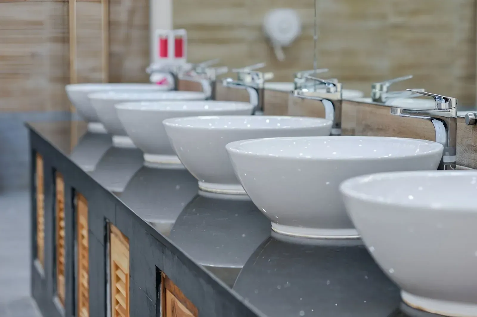 A Row of White Vessel Sinks With Silver Faucets — Dunnrite Plumbing Services in Airlie Beach, QLD