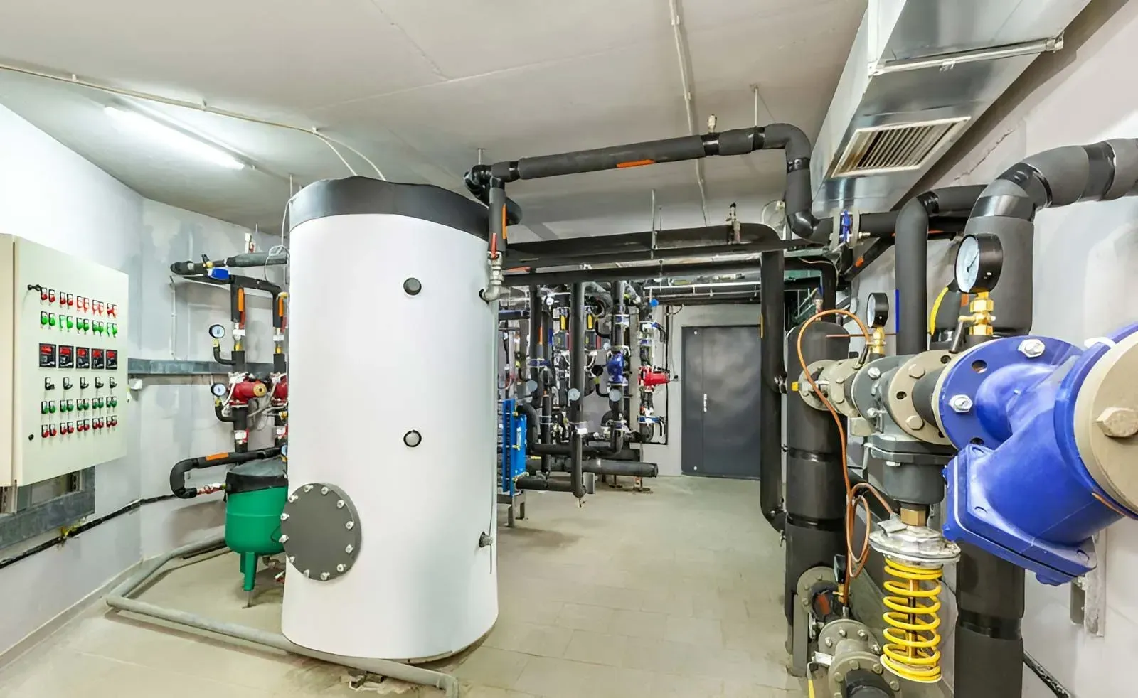 A Commercial Mechanical Room Featuring a Large White Water Heater — Dunnrite Plumbing Services in Airlie Beach, QLD