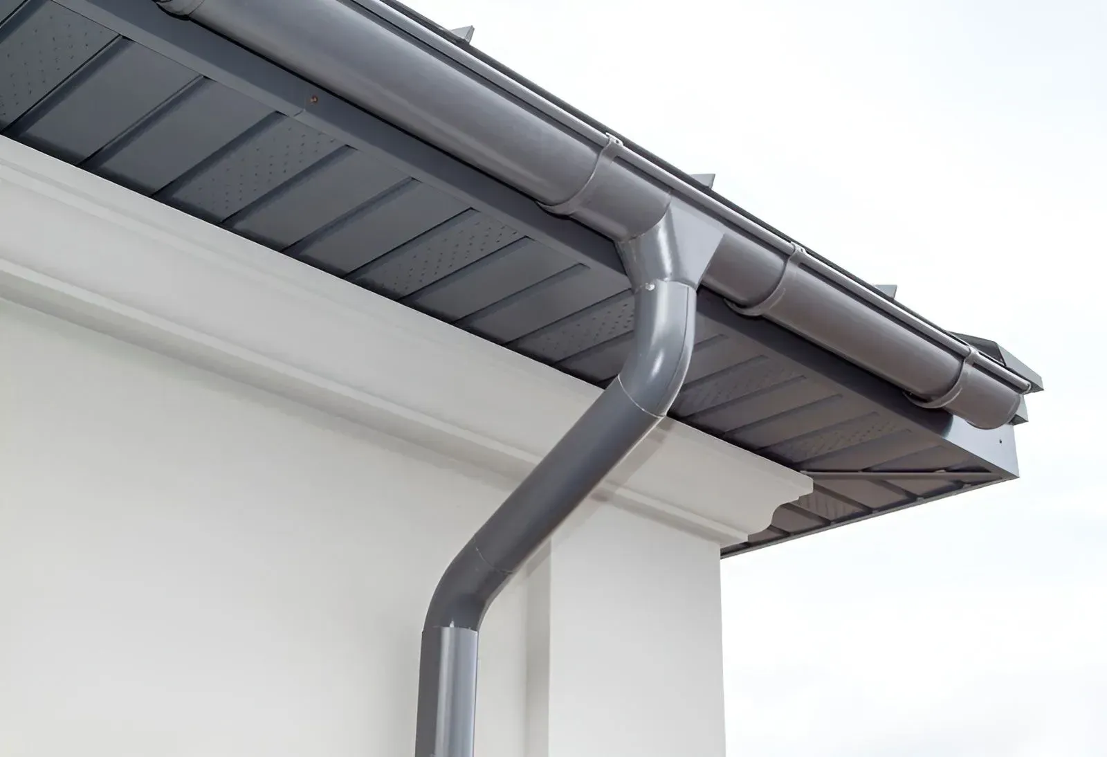 A Grey Metal Gutter and Downspout Installed on the Corner of the House — Dunnrite Plumbing Services in Cannonvale, QLD