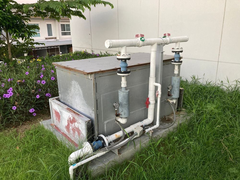 An Outdoor Water Pump System With White Pvc Pipes — Dunnrite Plumbing Services in Cannonvale, QLD