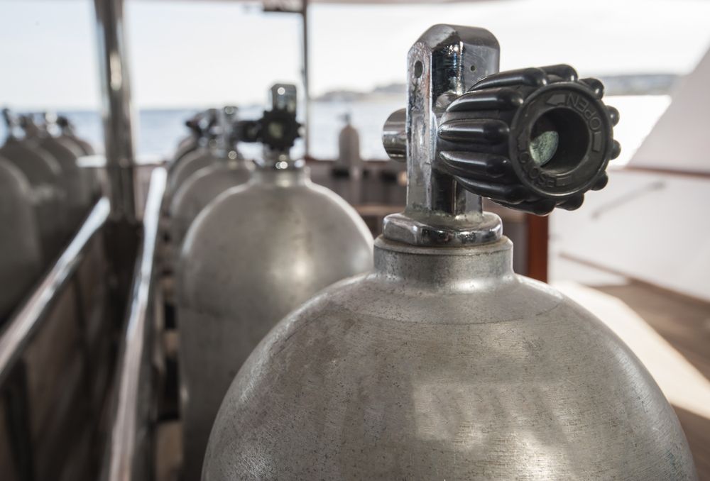 Row of Silver Scuba Tanks on a Boat Deck — Dunnrite Plumbing Services in Proserpine, QLD