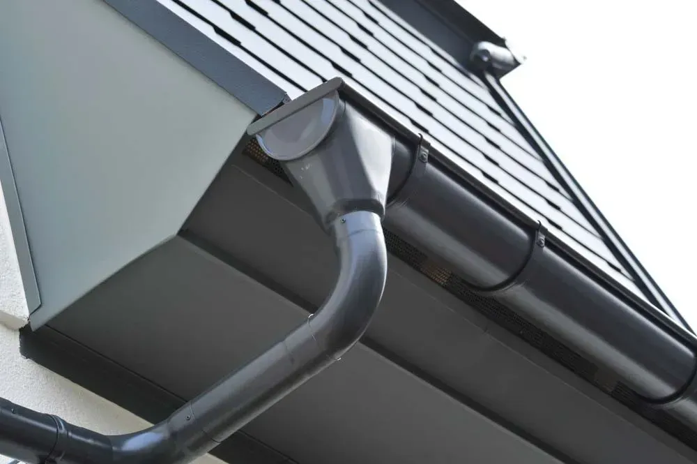 A Close-up View of a Dark Grey Metal Roof Gutter — Dunnrite Plumbing Services in Airlie Beach, QLD
