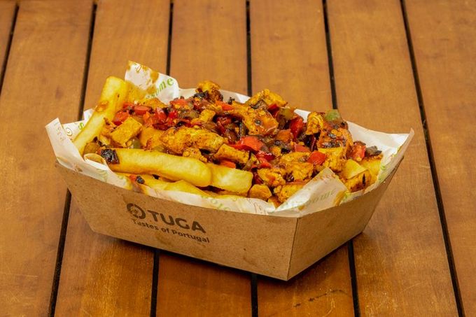 A tray of french fries with meat and vegetables on a wooden table — O Tuga Tastes Of Portugal In Melbourne, VIC