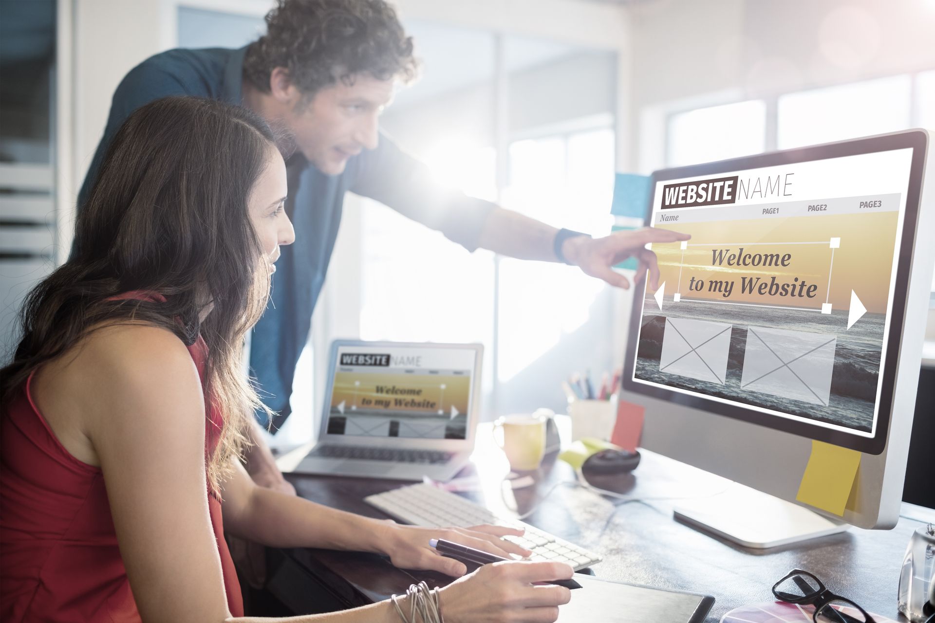 A man and a woman are looking at a computer screen.