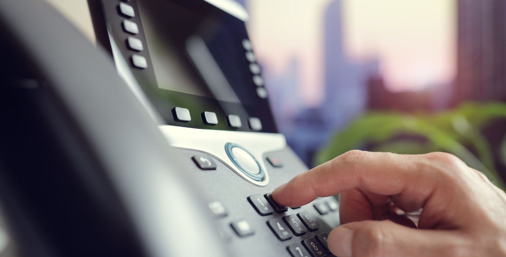 A person is pressing a button on a telephone.