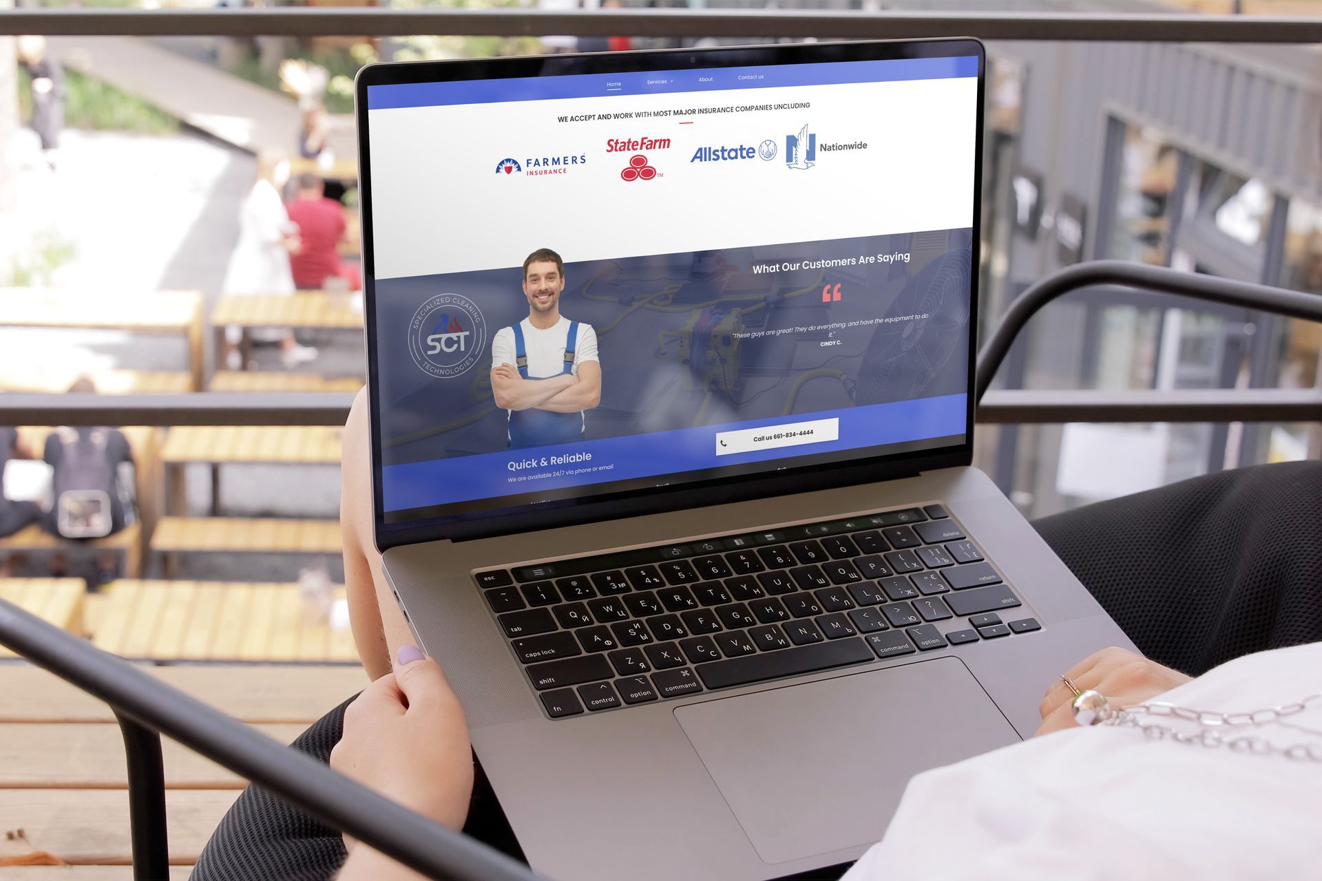 A person is holding a laptop viewing the Specialized Cleaning Technologies Website