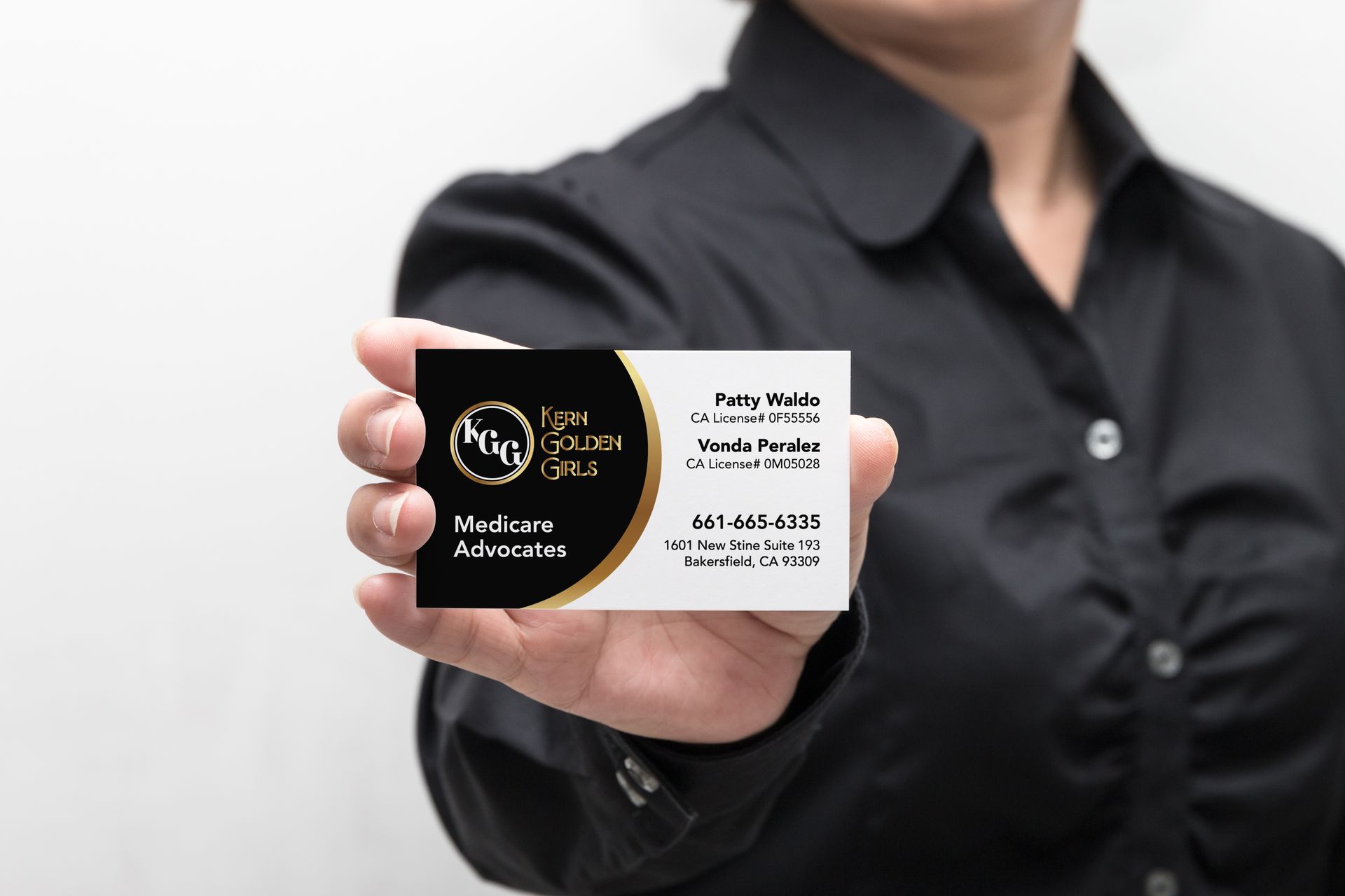 A woman in a black shirt is holding a Kern Golden Girls business card