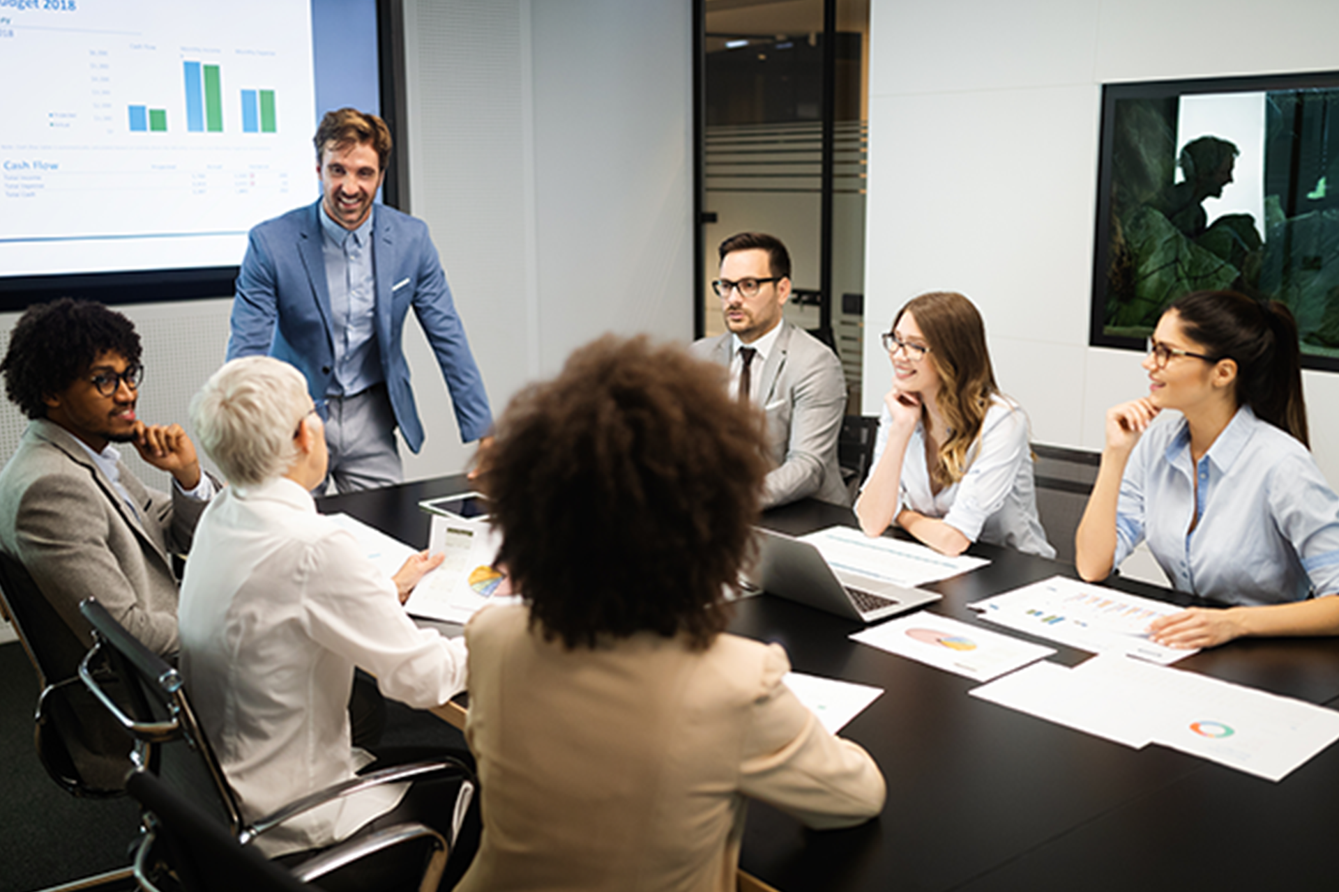 A group of people are sitting around a conference table having a meeting.