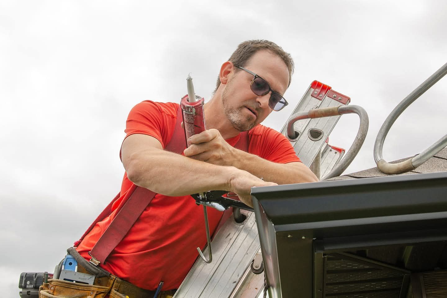 Un groupe d'hommes travaillent sur le toit d'une maison.