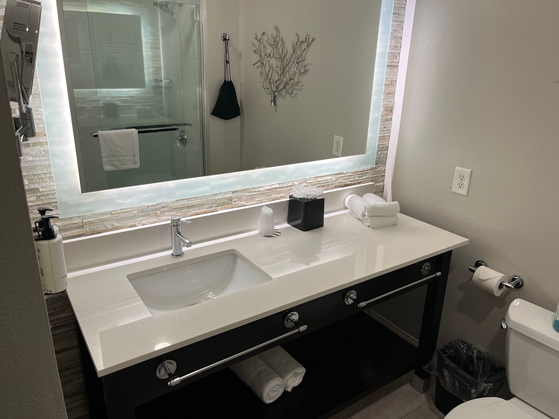 A bathroom with a sink , toilet and mirror.
