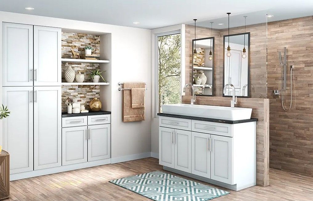 A bathroom with white cabinets , a sink and a shower.
