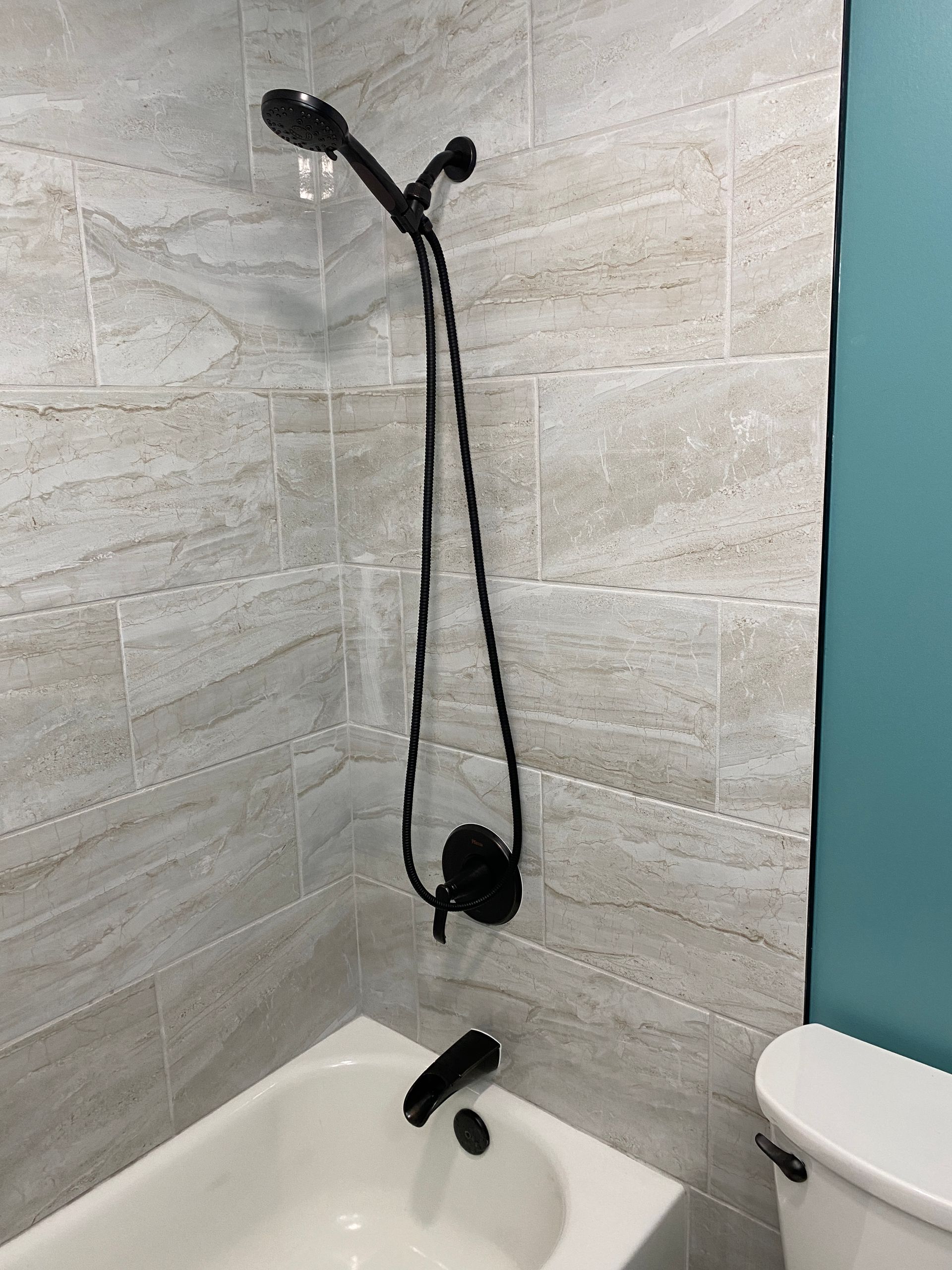 A bathroom with a bathtub , toilet and shower.