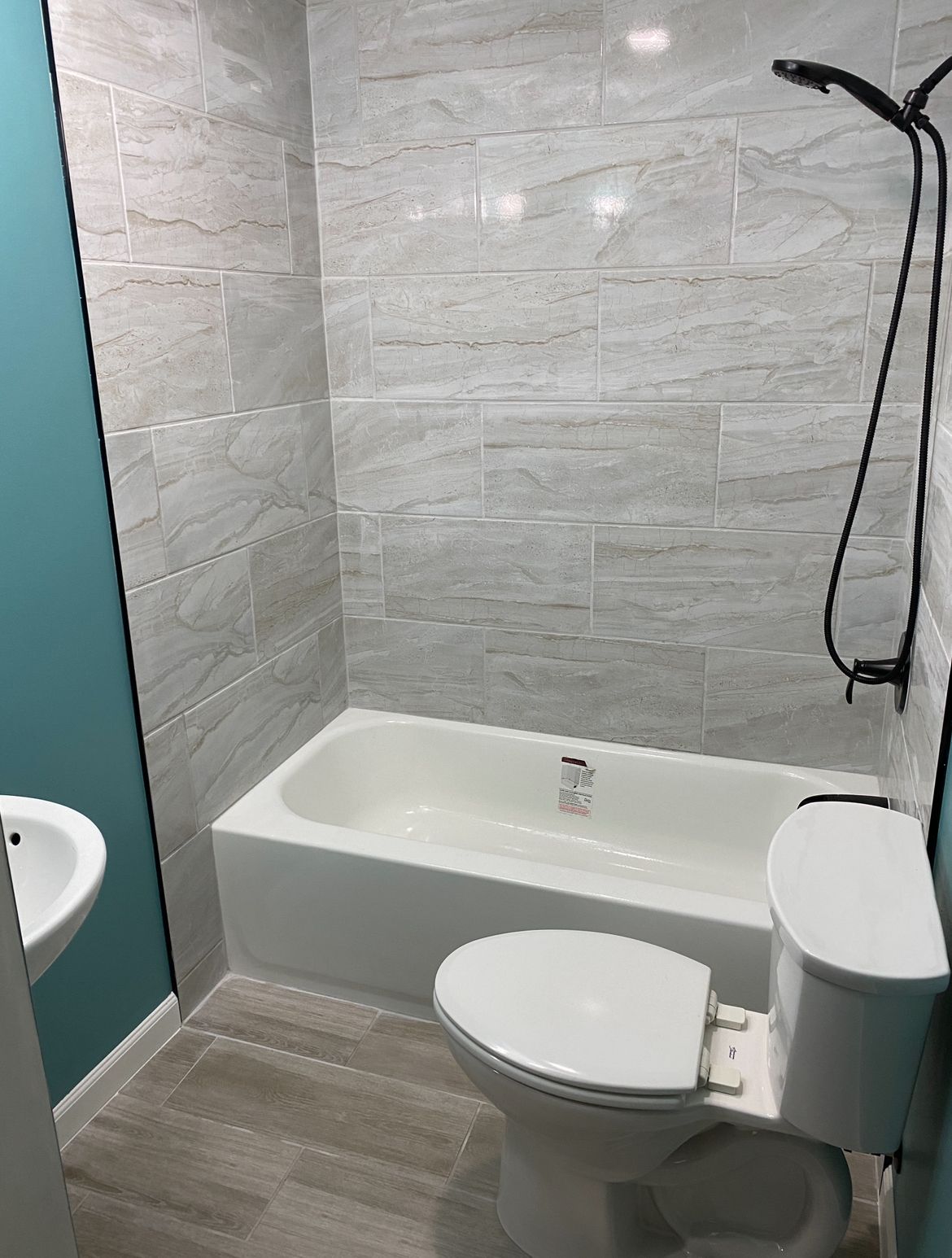 A bathroom with a toilet , sink and bathtub.