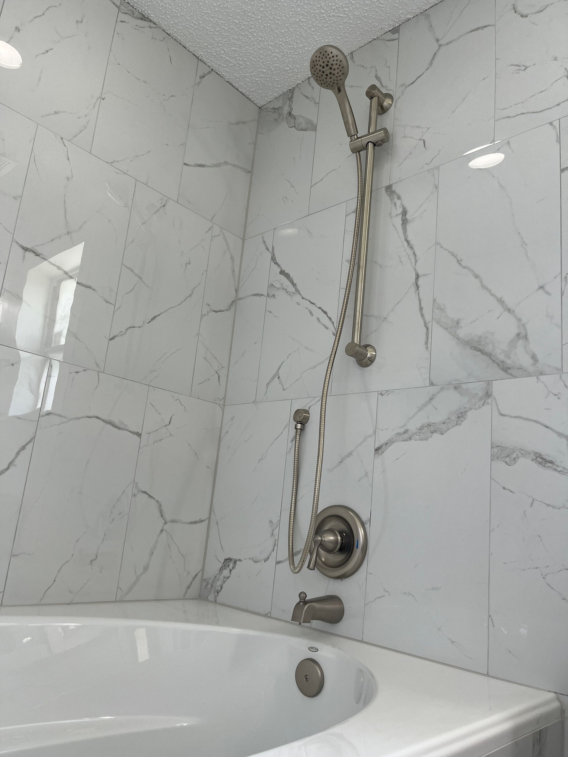 A bathtub with a shower head attached to it in a bathroom.