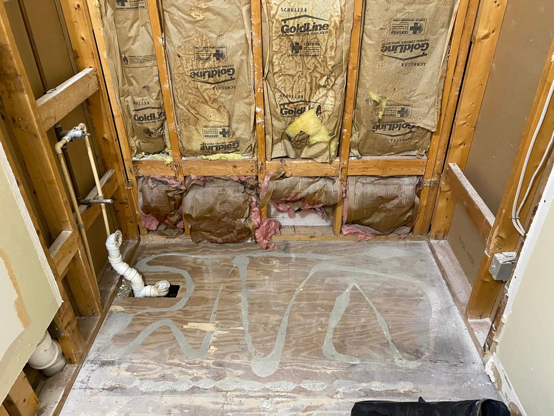 A bathroom under construction with wooden walls and a wooden floor.
