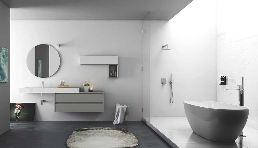 Bagno moderno con mobile lavabo sospeso grigio, specchio rotondo e vasca indipendente.