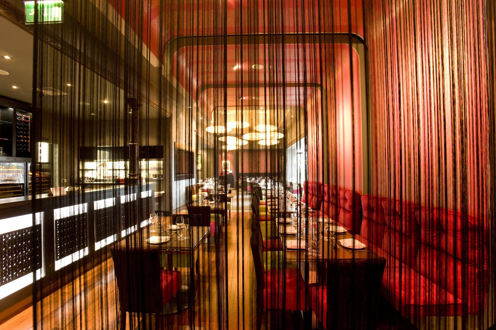 A restaurant with red walls and tables and chairs