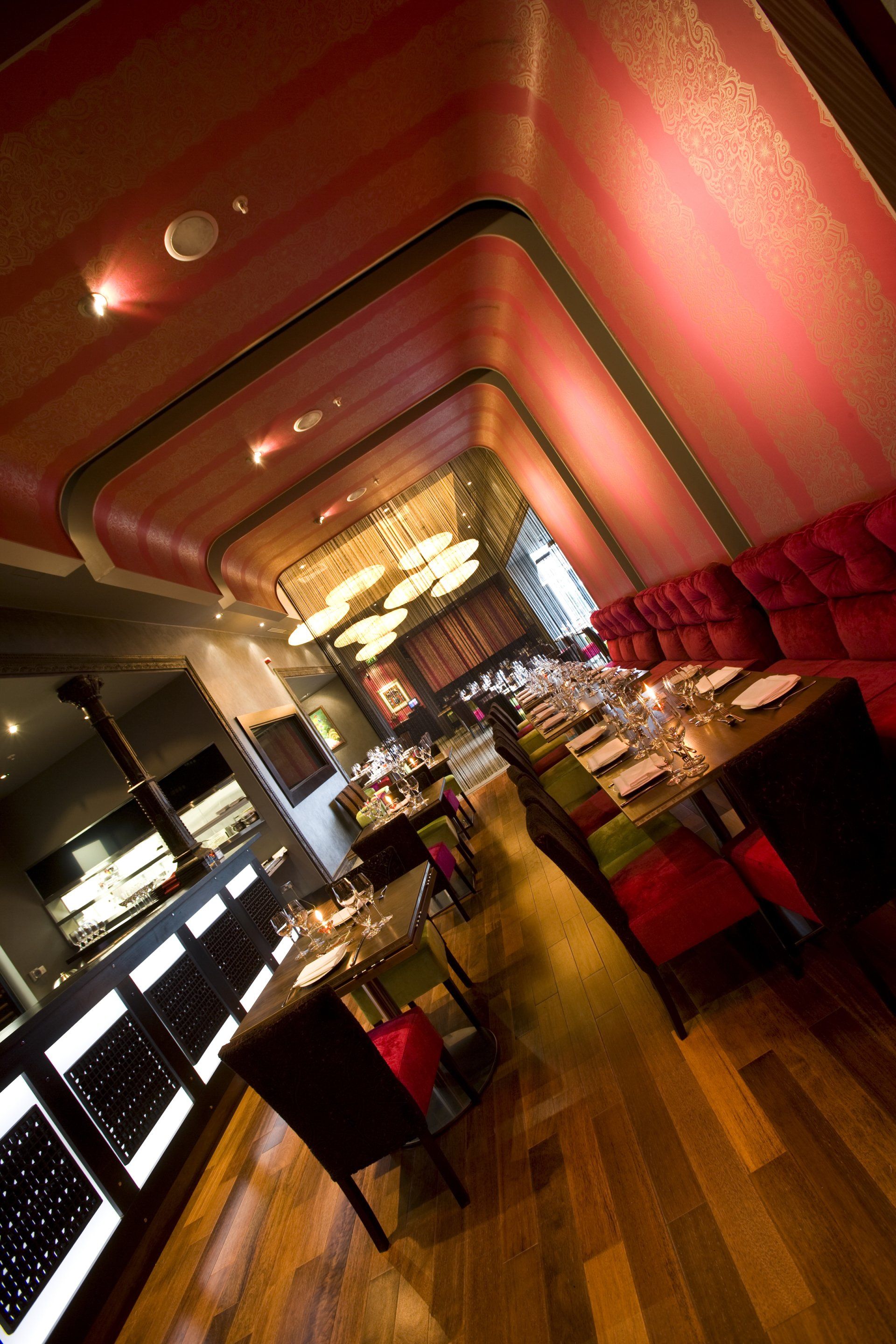 A restaurant with tables and chairs and a red ceiling