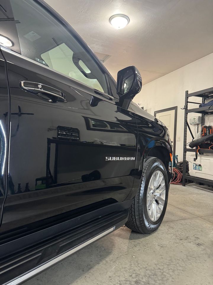 A black suv is parked in a garage.