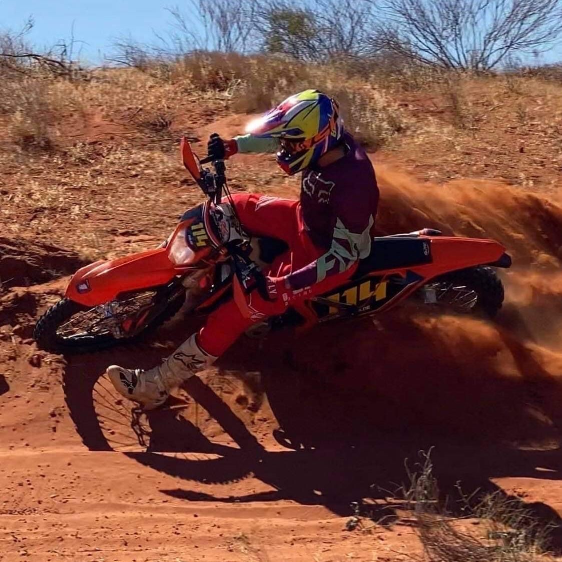 A person riding a dirt bike with the word fly on the back