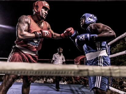 Two boxers are fighting in a boxing ring.