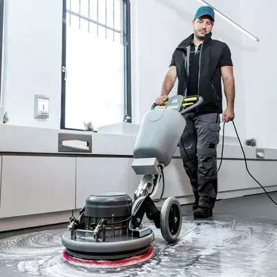 A man is cleaning the floor with a machine.