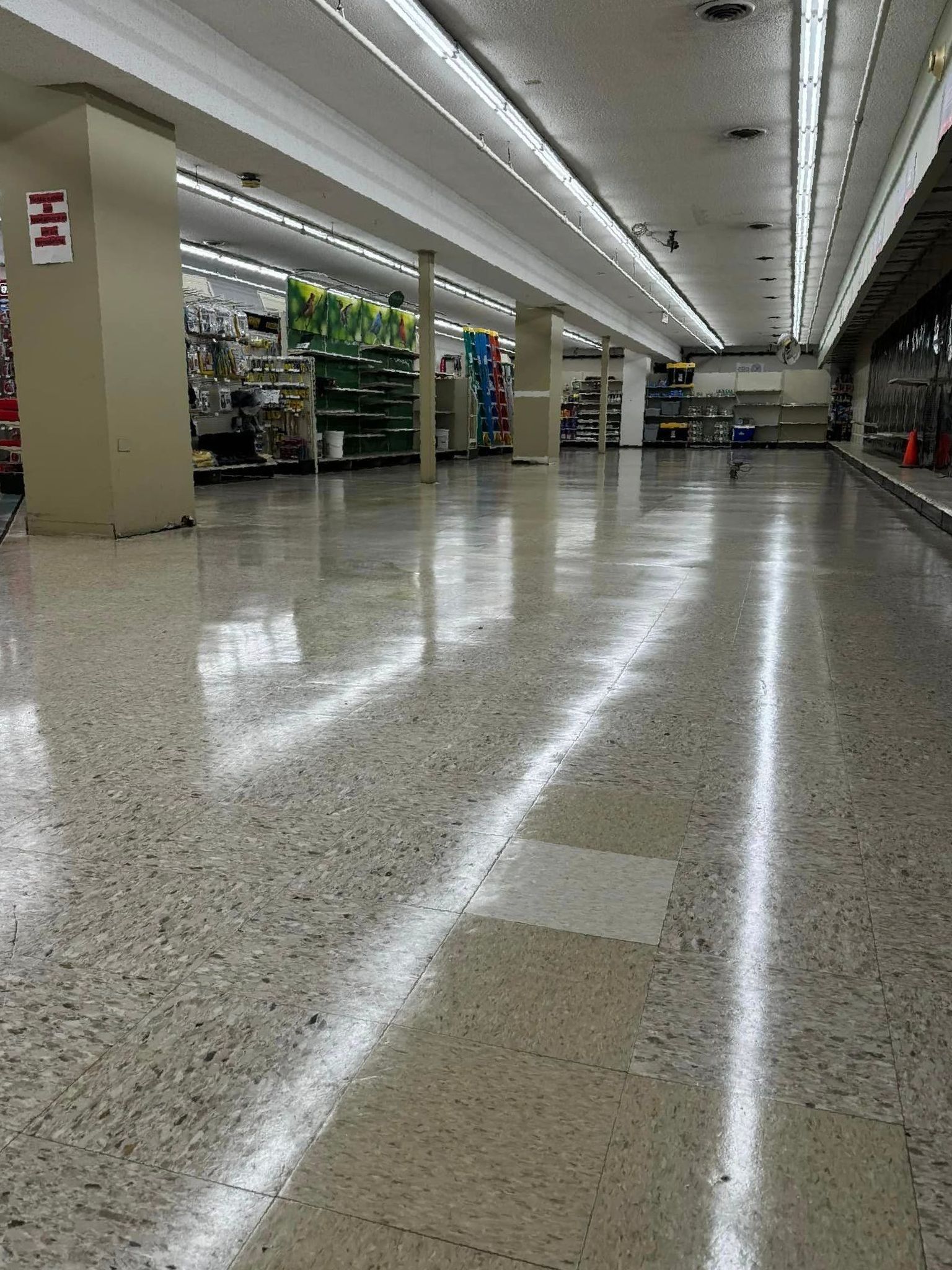A large empty store with lots of shelves and lights on the ceiling.